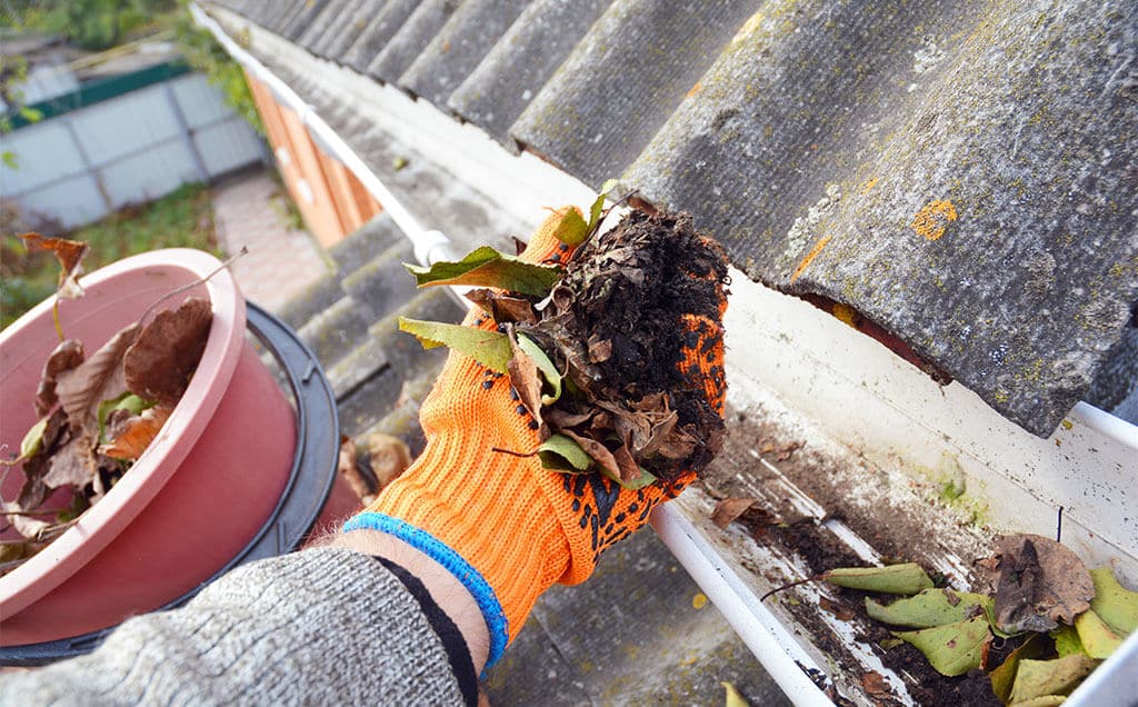 messy clogged rain gutter filled with debris