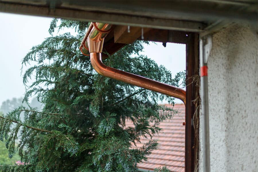 copper gutter leaderhead and downspout on coastal home in foggy weather