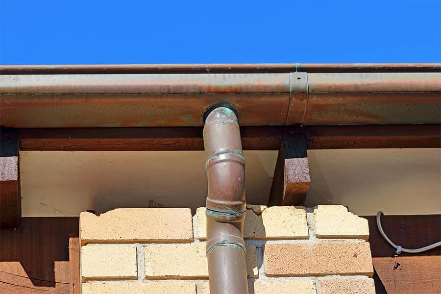 aged copper gutter and downspout system on northern california coastal home
